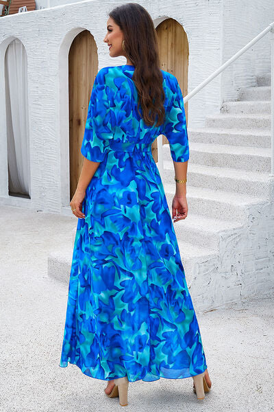 Back view of a woman in a vibrant blue floral printed half sleeve dress, showcasing a casual, stylish look.