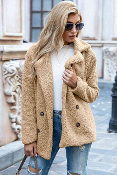 Woman wearing a full size lapel collar sherpa coat in beige, styled casually with sunglasses and jeans.
