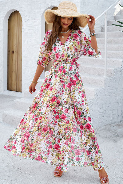 Model wearing a floral printed tied half sleeve dress with a hat, standing on a staircase.