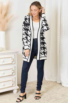 Elegant woman in houndstooth open front longline cardigan styled with jeans, showcasing versatility and comfort.