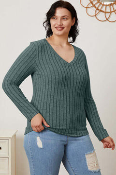 Model wearing a teal ribbed v-neck long sleeve t-shirt paired with jeans, showcasing a casual and stylish look.