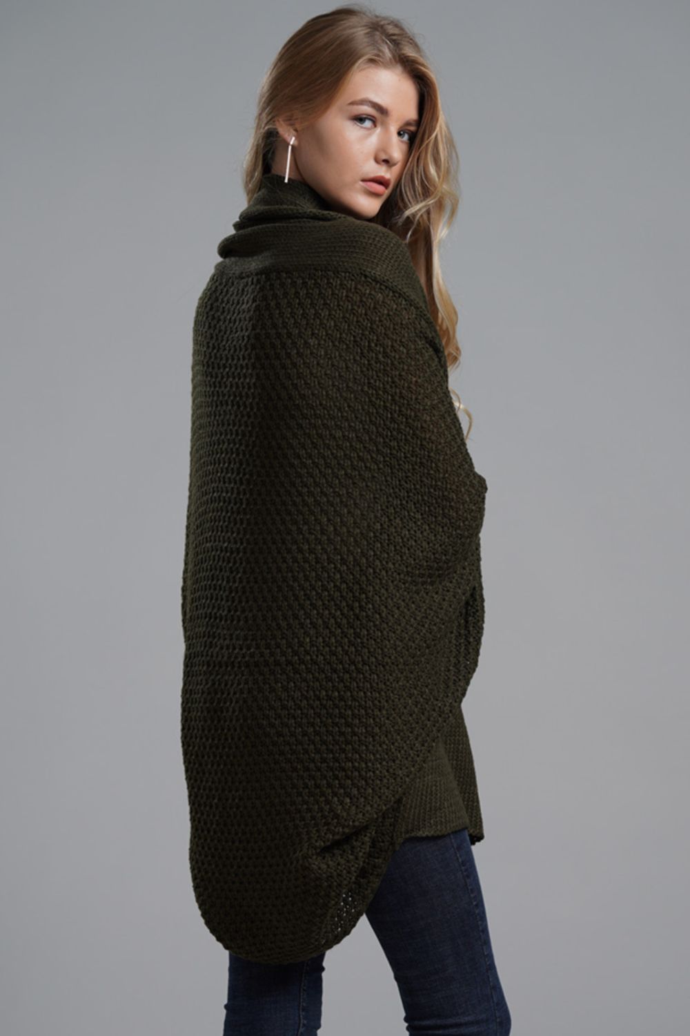 Model wearing a longline cardigan with dolman sleeves in olive green, showcasing ribbed details and open front style.