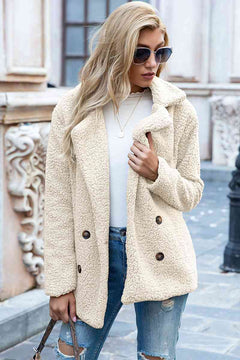 Woman in a cream sherpa coat with a lapel collar, styled casually with sunglasses and jeans.