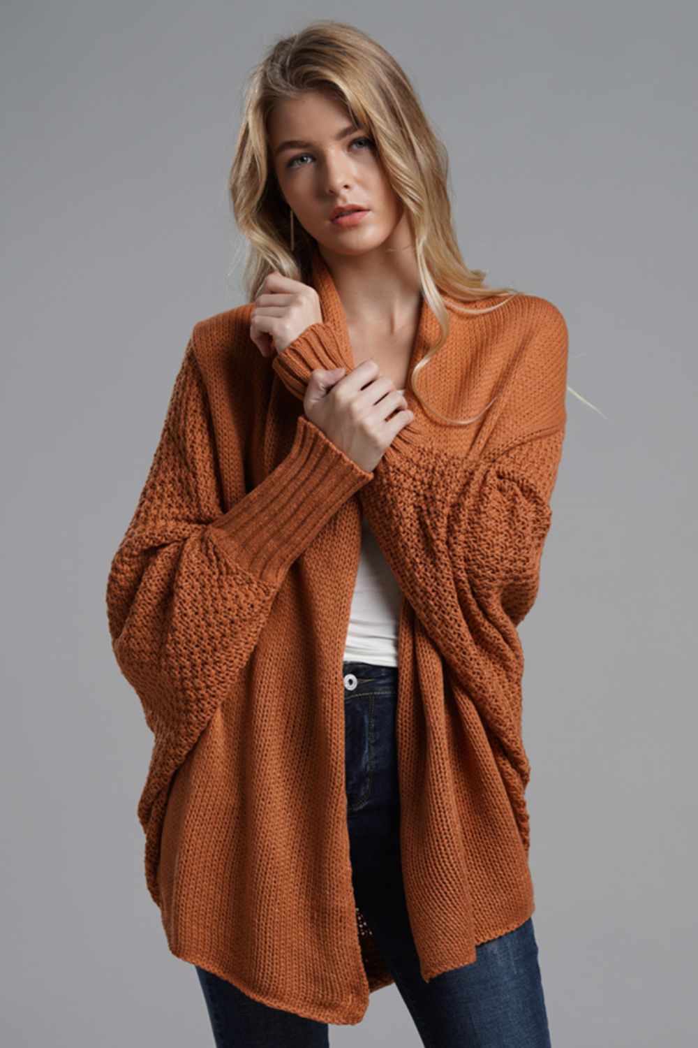 Woman wearing a chic open front ribbed trim longline cardigan in rust color, styled for a casual look.