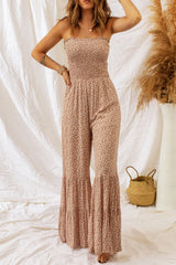 Floral Spaghetti Strap Smocked Wide Leg Jumpsuit featuring a smocked neckline and floral pattern against a textured background.
