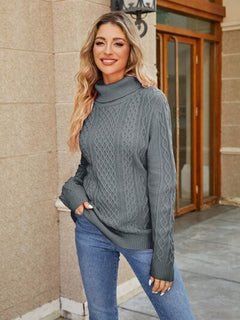 Model wearing a stylish grey cable-knit mock neck sweater paired with jeans outside.