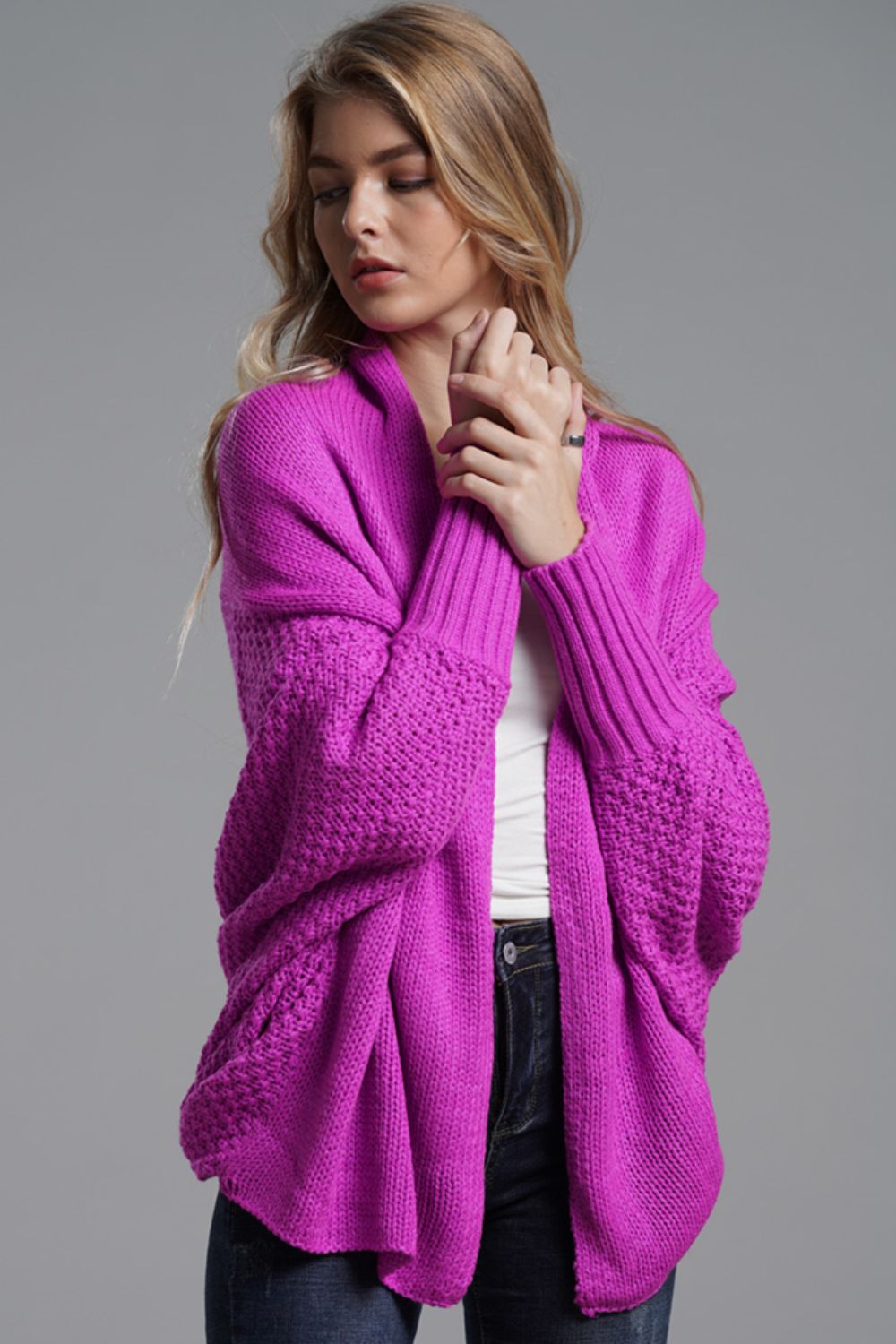 Model wearing a vibrant purple double take dolman sleeve open front cardigan styled with casual jeans.