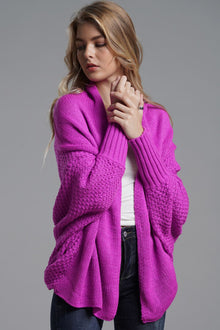 Model wearing a vibrant purple double take dolman sleeve open front cardigan styled with casual jeans.