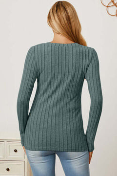 Back view of a woman wearing a ribbed teal long sleeve T-shirt, showcasing its fitted design and soft fabric.