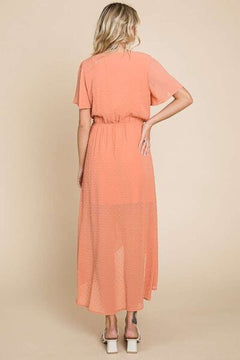Back view of Chic Swiss Dot Dress in peach color, showcasing ruffled sheer fabric and adjustable waist for elegant fit.