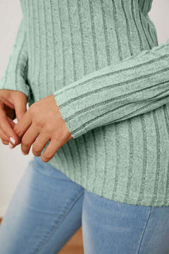 Close-up of teal ribbed long sleeve t-shirt paired with light blue jeans, showcasing texture and fit.