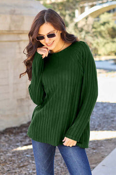 Model wearing a green ribbed knit top with long sleeves and sunglasses, showcasing casual stylish comfort.