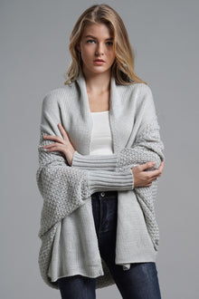 Model wearing a light grey dolman sleeve open front ribbed cardigan, styled with a white tank and jeans.