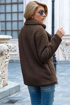 Woman wearing a brown sherpa coat with lapel collar and casual style, showcasing a fashionable urban look.