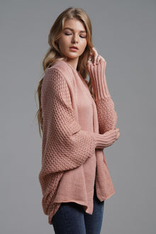 Model wearing a blush pink dolman sleeve open front ribbed cardigan, showcasing a chic, casual style.