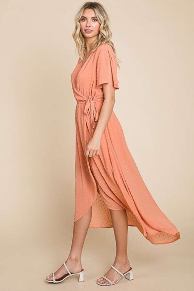 Chic Swiss Dot Dress in soft peach, showcasing ruffled details and stylish silhouette for any occasion.