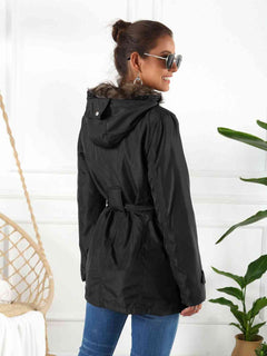 Black hooded jacket with detachable liner, featuring a belted waist and faux fur trim, perfect for stylish three-way wear.