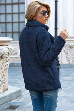 Woman wearing a navy blue full size lapel collar sherpa coat, stylish and casual, perfect for urban settings.