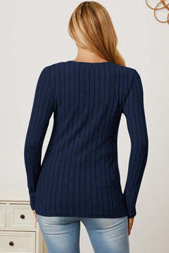 Back view of a woman wearing a navy ribbed long sleeve V-neck T-shirt, highlighting the soft stretch and basic style.
