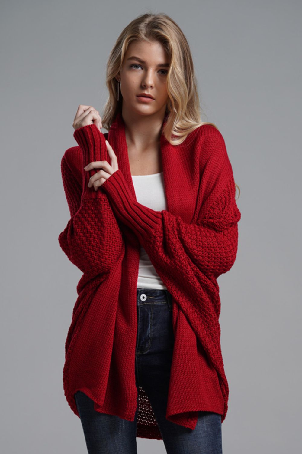 Chic red longline cardigan with dolman sleeves and ribbed details, perfect for casual styling and layering.