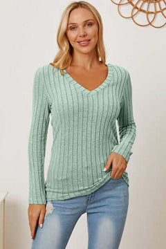 Model wearing a mint green ribbed V-neck long sleeve T-shirt paired with jeans, showcasing a casual style.